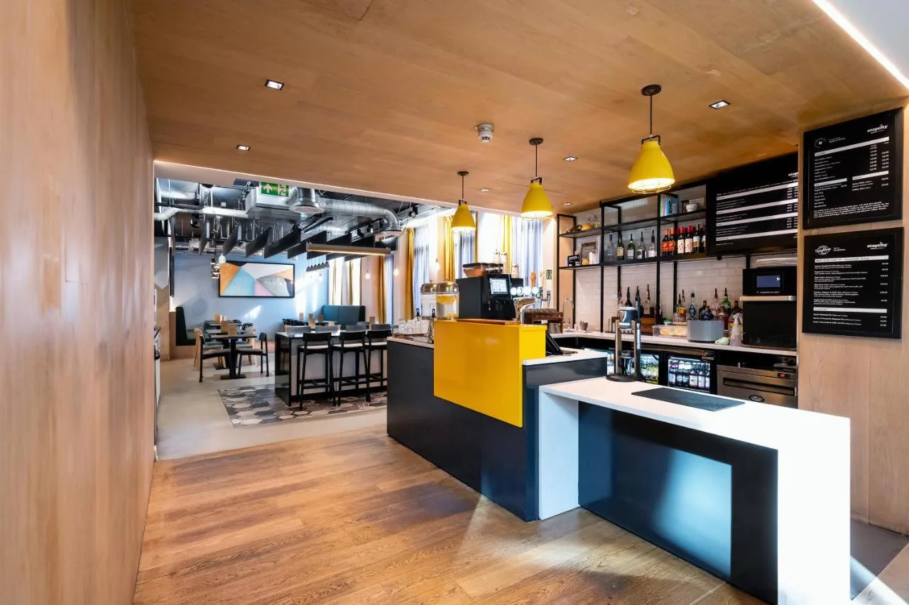 a bar in a restaurant with a yellow and black counter at Staycity Aparthotels Liverpool Waterfront in Liverpool